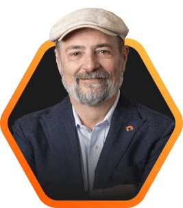 Headshot of Everpure CEO, Charlie Giancarlo, smiling, wearing a cap and a jacket