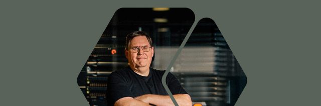 Person standing confidently with arms crossed against a dark background