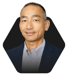 Professional Headshot with a Warm Smile featured in a hexagonal frame on a dark background