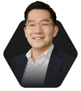 Professional Headshot with a Warm Smile featured in a hexagonal frame on a dark background
