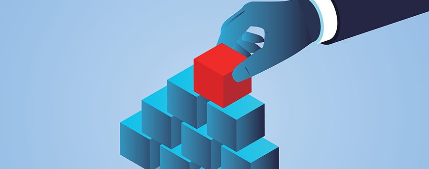Hand holding red square to finish stacking last block; Shutterstock ID 1739943893; purchase_order: 01; job: ; client: ; other: 