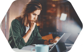 Thoughtful young professional engaged in laptop work in a warm setting