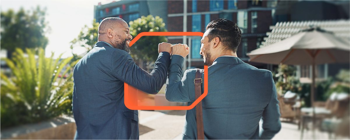 Two colleagues exchanging an elbow bump while enjoying the outdoors